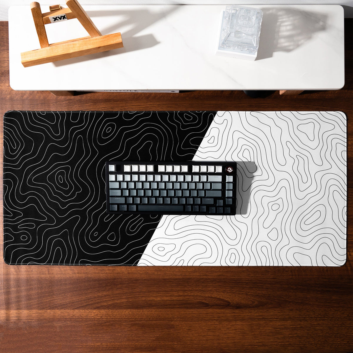XVX black-and-white Topographic desk mat beneath a keyboard